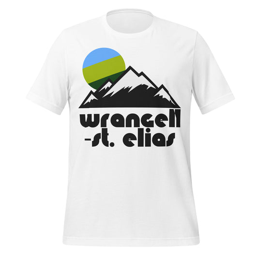 A retro 80s style white t-shirt that says "Wrangell-St. Elias", a national park in Alaska, and includes snow covered mountain peaks and a blue and green colored sun. The national park is the largest in the United States, known for its immense glaciers and volcanoes, old mining towns, and nine of the tallest sixteen mountains in the US.