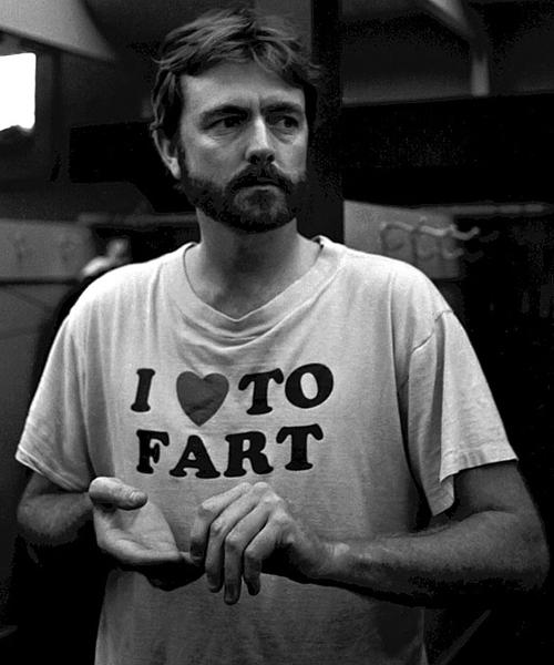 A man wearing a white t-shirt with the text "I [heart symbol] TO FART" printed on it.