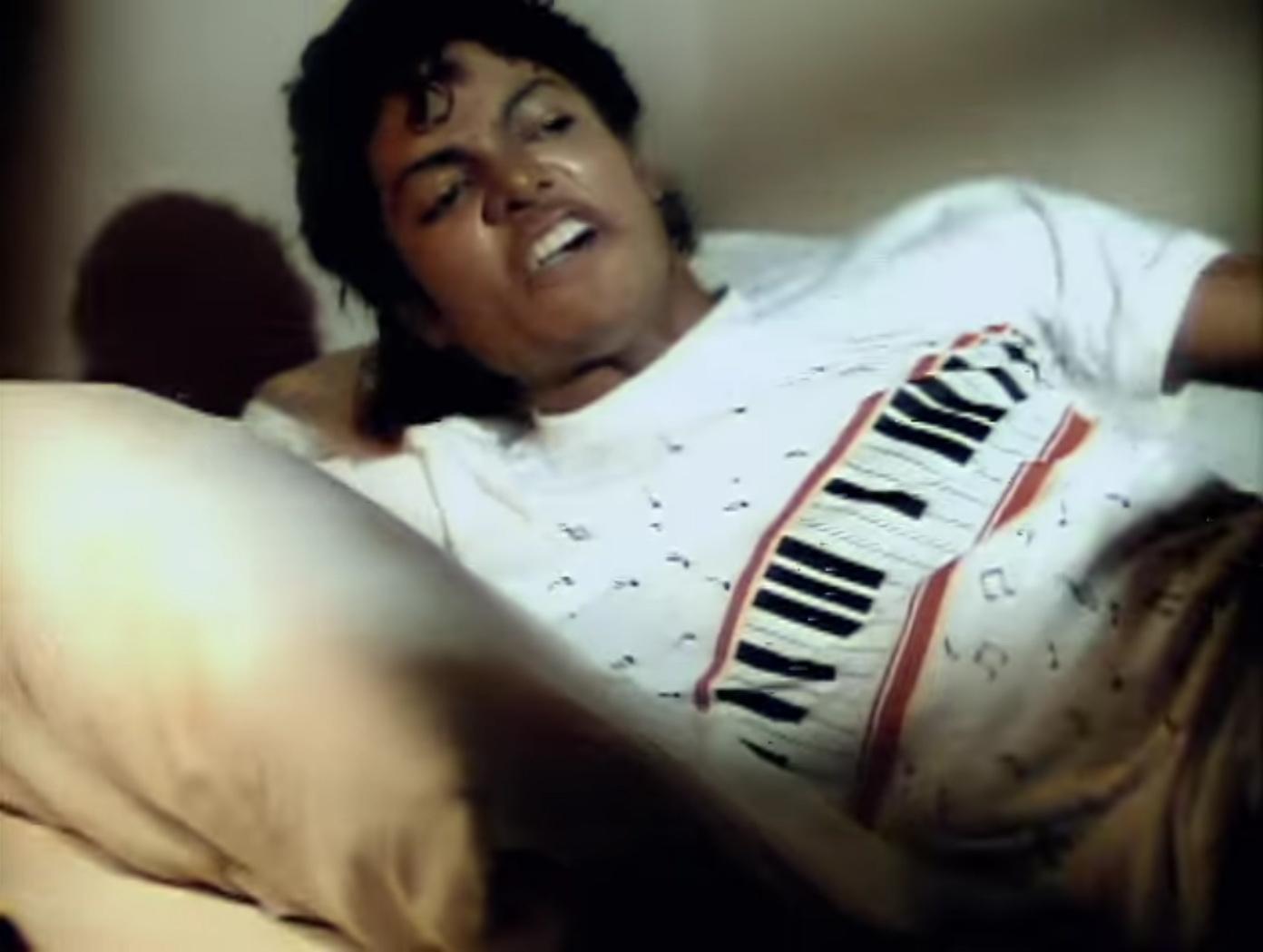 a woman laying on top of a bed next to a pillow