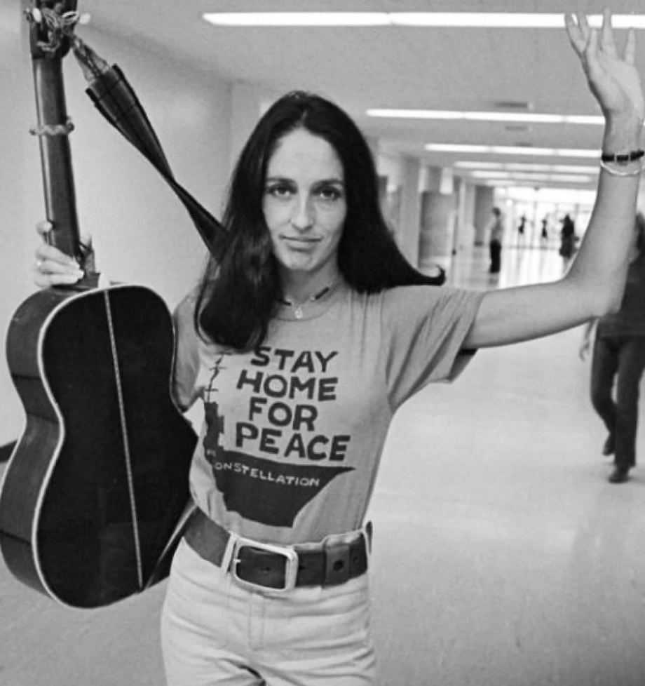 a woman holding a guitar in a hallway