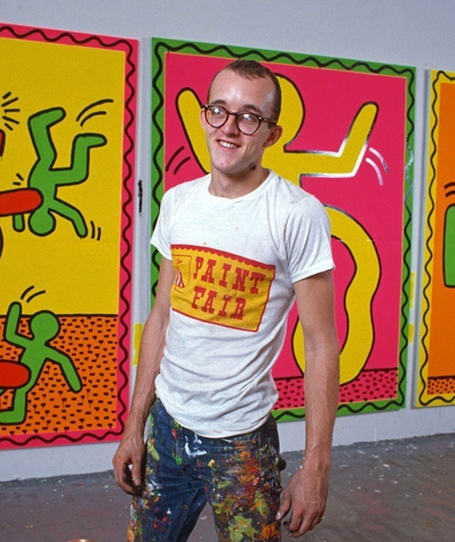 a man standing in front of two paintings