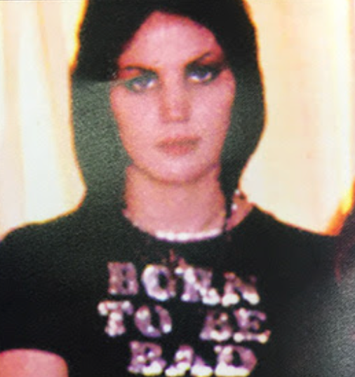 A close-up of a person wearing a black t-shirt with the text "Born to be bad" printed on it.