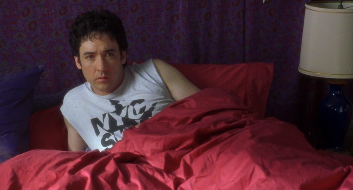 a man laying in bed with a red comforter