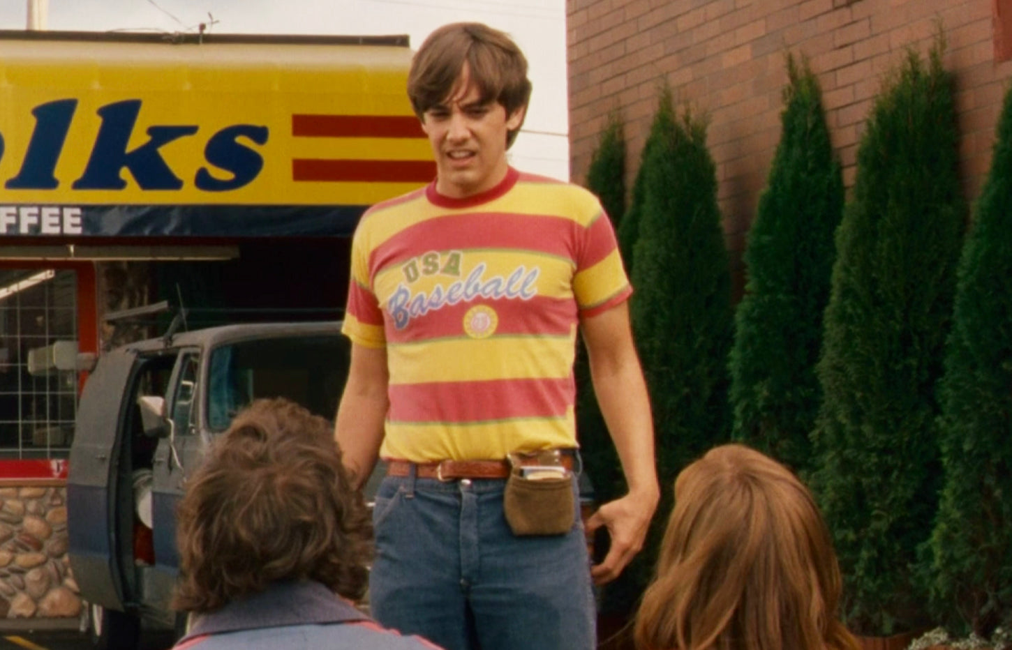 a man standing in front of a store talking to a group of people