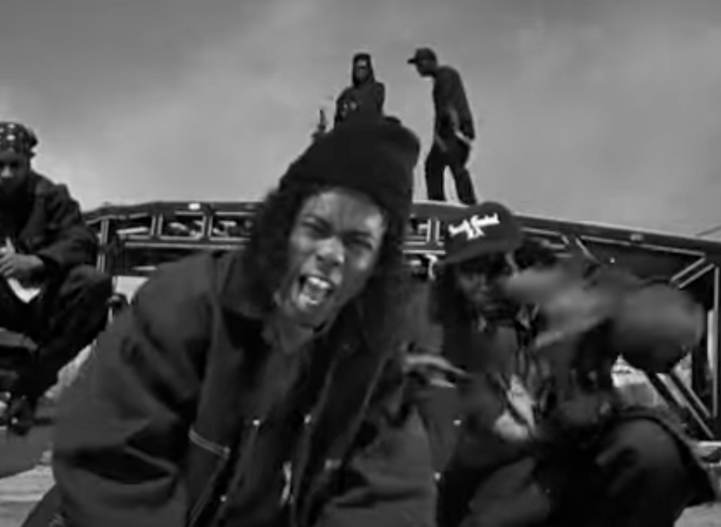 a group of men sitting on top of a bridge