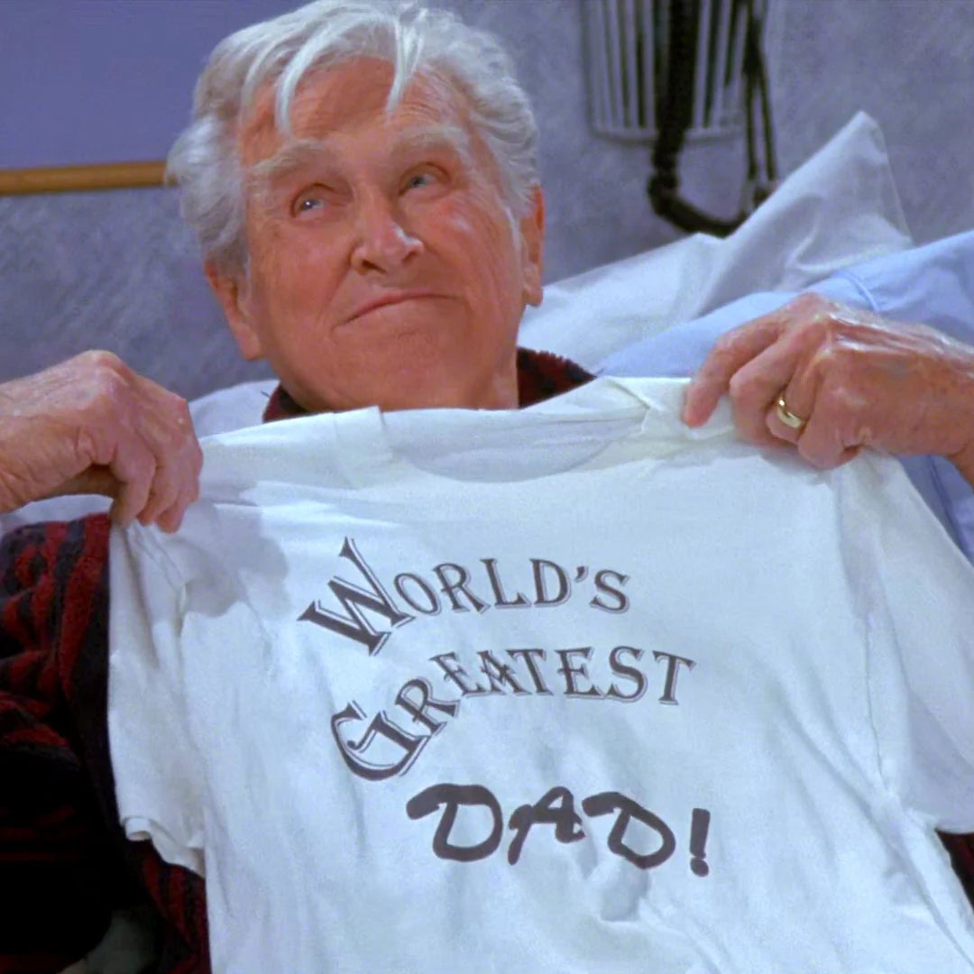 an older woman holding up a t - shirt that says world's greatest dad