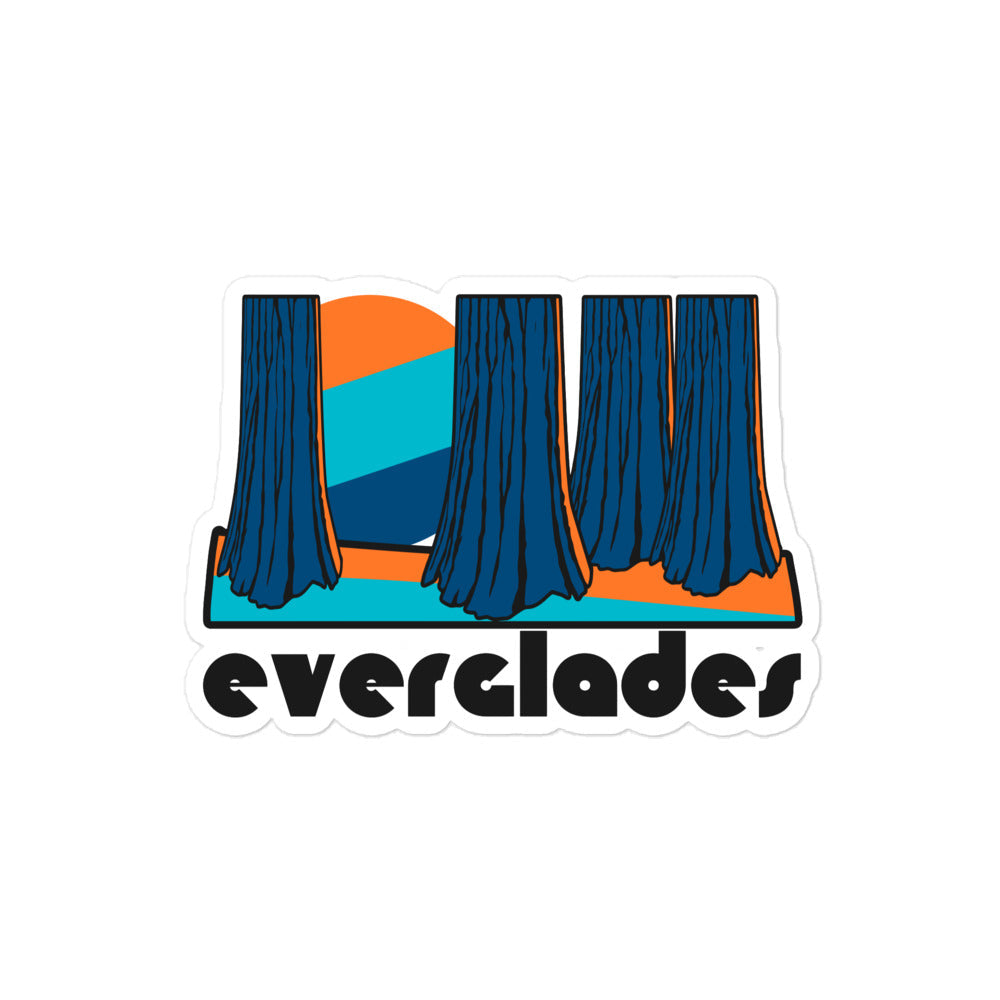 A retro blue and orange kiss cut sticker that says "Everglades" under an image of multiple trees, a sun peaking through aesthetically, in reference to Everglades National Park in Florida. 