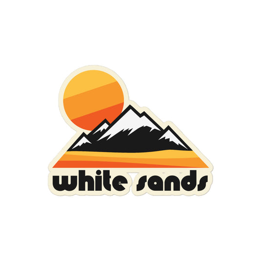 A "White Sands" retro souvenir kiss cut sticker with an image of a yellow and orange dessert, tall mountains with snowy peaks behind, referencing New Mexico's White Sands National Park. 