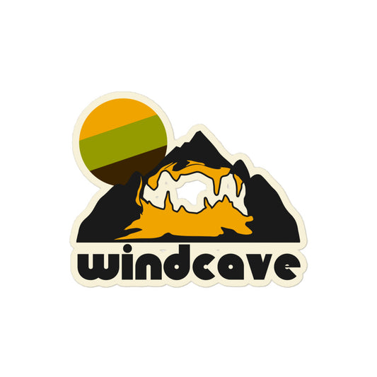 A white kiss cut retro sticker that says "Windcave" referencing Wind Cave hiking trail, one of the most complex caves in the entire world. Image of a mountain and a hiking trail within and a tricolored sun in yellow, green, and brown. 