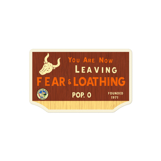 A "You Are Now Leaving Fear & Loathing" kiss cut sticker with the image of a horned bull and a City of Las Vegas Nevada stamp. Says Pop. 0 and Founded 1971. Refers to the movie Fear and Loathing in Las Vegas. Background looks like brown tree bark. 