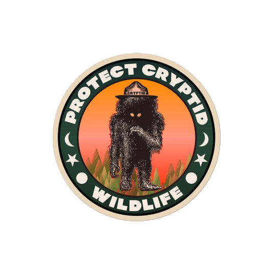 A circular retro kiss-cut sticker that says "Protect Cryptid Wildlife" with s un, star, and the moon. Has image of an unknown black furry creature with yellow eyes and hat that says "Cryptid" in green trees in front of orange and pink sunset. About preserving biodiversity and respect for the environment. 
