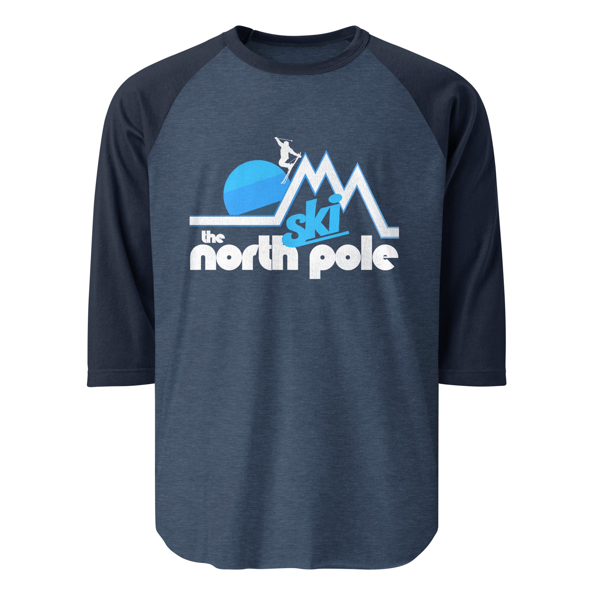 A three quarter sleeve retro raglan style t-shirt that says "Ski the north pole" underneath the image of a person skiing through a beautiful mountain landscape, multiple peaks sticking up like triangles, a blue sun setting in the distance. 