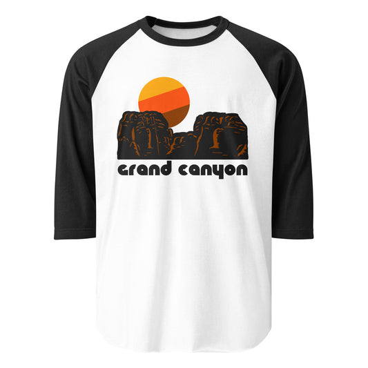 A black and white three quarter sleeve vintage raglan style shirt with an image of red rock formations, similar to the landscape of the Southwestern United States, with a warm toned stylized sun. In reference to Grand Canyon National Park with popular destinations like South Rim, Mather Point, Rim Trail, Bright Angel Trail, and Desert View Drive. 