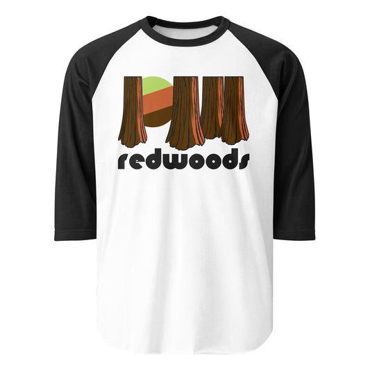 A 3/4 sleeve black and white retro raglan style shirt that says "redwoods" in a bold black font underneath an image of these majestic trees, a rising sun poking through the trunks. References the Californian Redwood National Park, renowned for its incredible redwood trees, including the tallest in the world. 