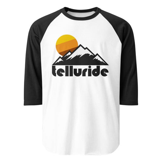 A black and white raglan style retro three quarter sleeve shirt with the image of multiple mountains, their peaks covered in snow, perfect for skiing, as a sun sets in the distance, the word 'telluride' underneath. In reference to the world famous Telluride Ski Resort, located in the Rocky Mountains (specifically the San Juan Mountains) and spanning from Telluride, CO to Mountain Village, CO. 
