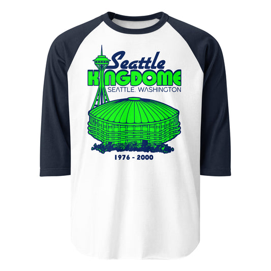 An white and navy 3/4 sleeve raglan style shirt for tourists that says "Seattle Kingdome", the famous multipurpose stadium from "Seattle, Washington" which stood from "1976 - 2000". Home of the Mariners, Seahawks, SuperSonics, and Sounders. Image of the famous domed multipurpose and the Space Needle, an iconic tourist attraction, in a bright green color. 