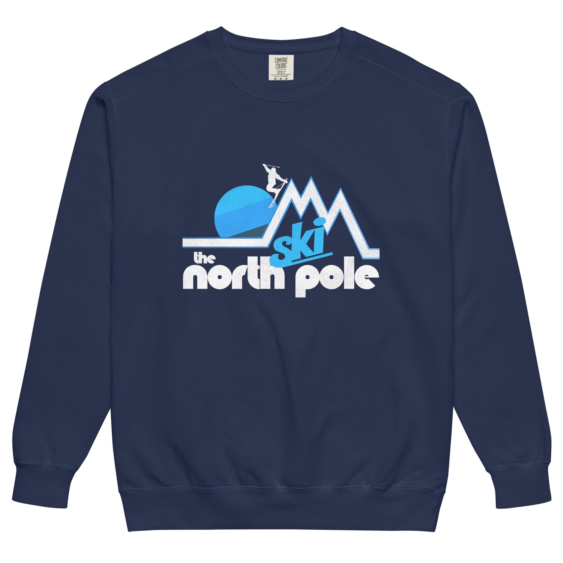 A true navy crew neck sweatshirt for tourists and travel that says "Ski the north pole" underneath a skier on triangular mountain slopes, doing a stylized ski jump, a striped blue hued sun in the distance. 