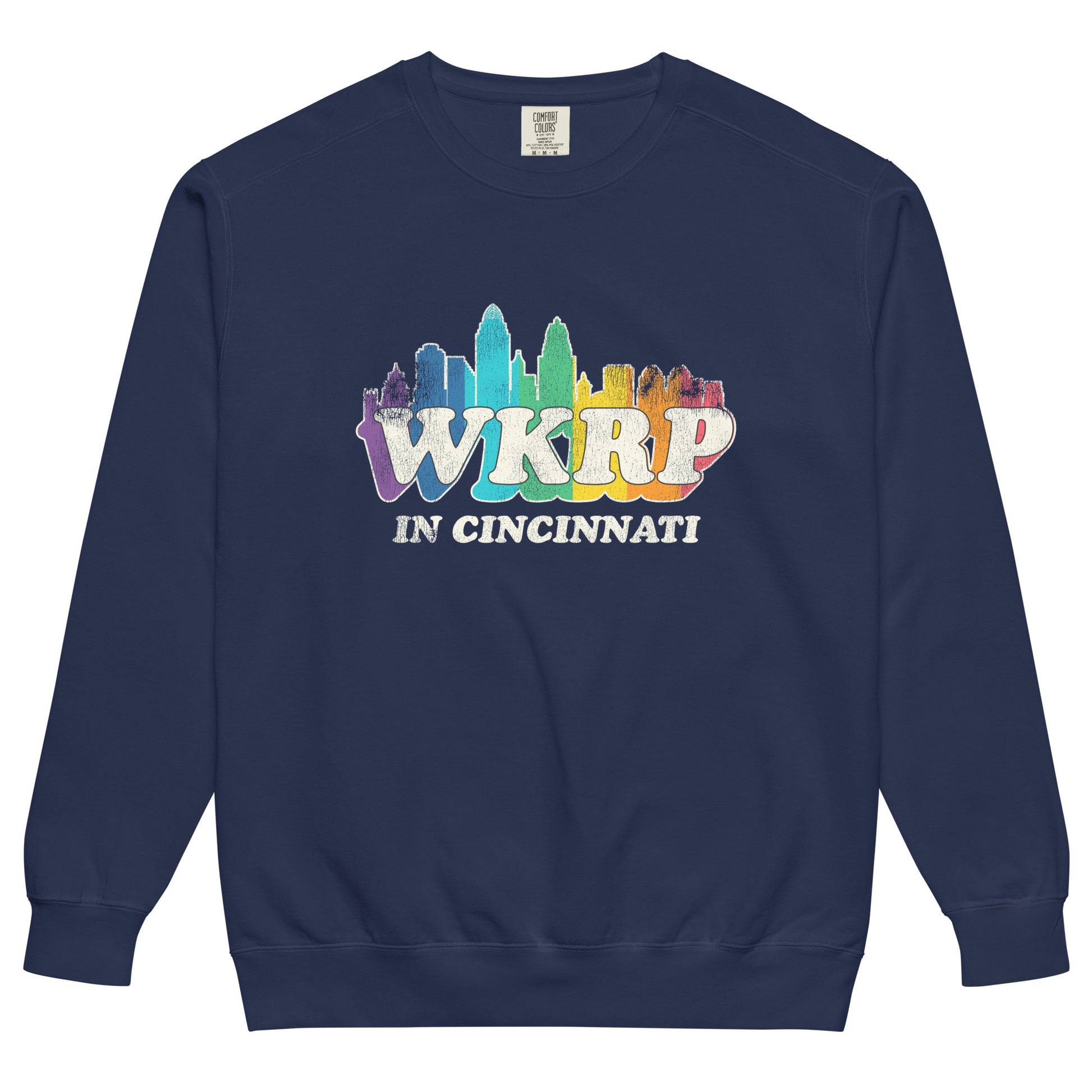 A retro true navy blue WKRP in Cincinnati crew neck sweatshirt with a rainbow colored skyline image of the Ohio city. Name of the 70s and 80s sitcom that ran on CBS. 