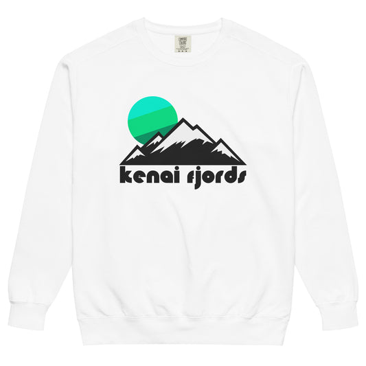 A vintage, 80s style white crew neck sweatshirt that says 'kenai fjords' and includes the image of an icy and snowy mountain range under a cool toned blue and green sun setting. In reference to the glacial wonderland known as Kenai Fjords National Park in Seward, Alaska, famous for its location right on the Pacific Ocean and its many glaciers, reminiscent of the Ice Age. 