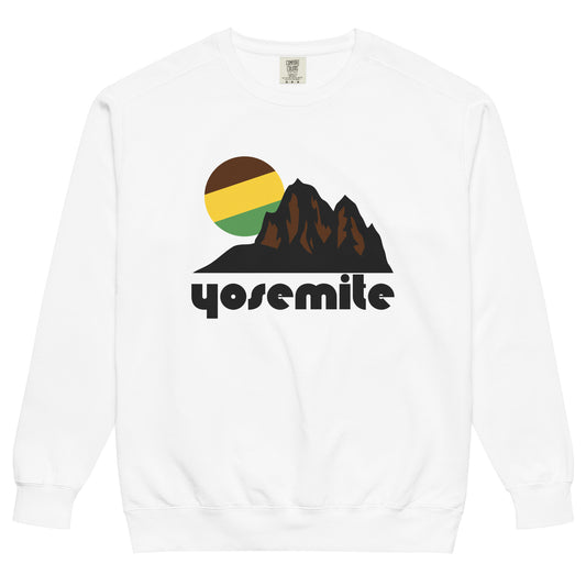 A white colored 70s style souvenir Yosemite National Park crew neck sweatshirt with the image of a mountain landscape and a sun or moon in green, yellow, and brown colors behind. Known as California's most famous national park and for its waterfalls and stunning hiking trails in the Sierra Nevadas. 