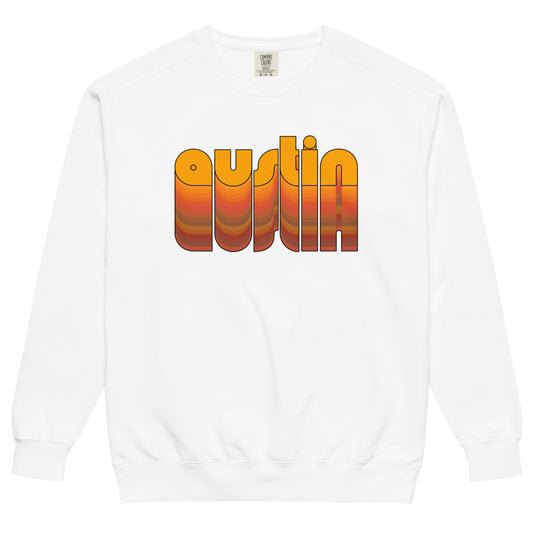 A white crew neck 70s style Austin, Texas sweatshirt for travel. Includes the word "Austin" in lowercase, orange, bubble letters that fade into many other colors. 