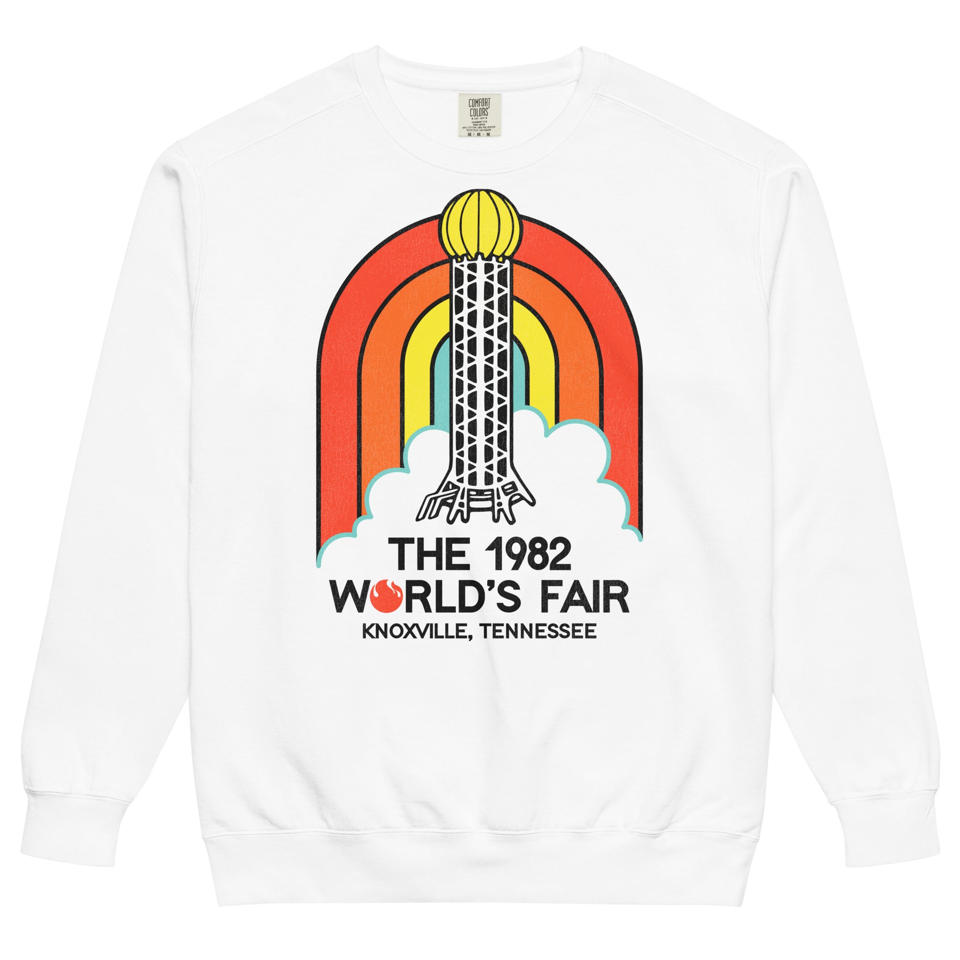 A white crew neck sweatshirt for tourists that says "The 1982 World's Fair" from "Knoxville, Tennessee". Image of a red, orange, yellow, and blue rainbow and clouds and the famous Sunsphere steel tower with a gold colored globe on top, an iconic image of the fair with its theme of "Energy Turns the World". 