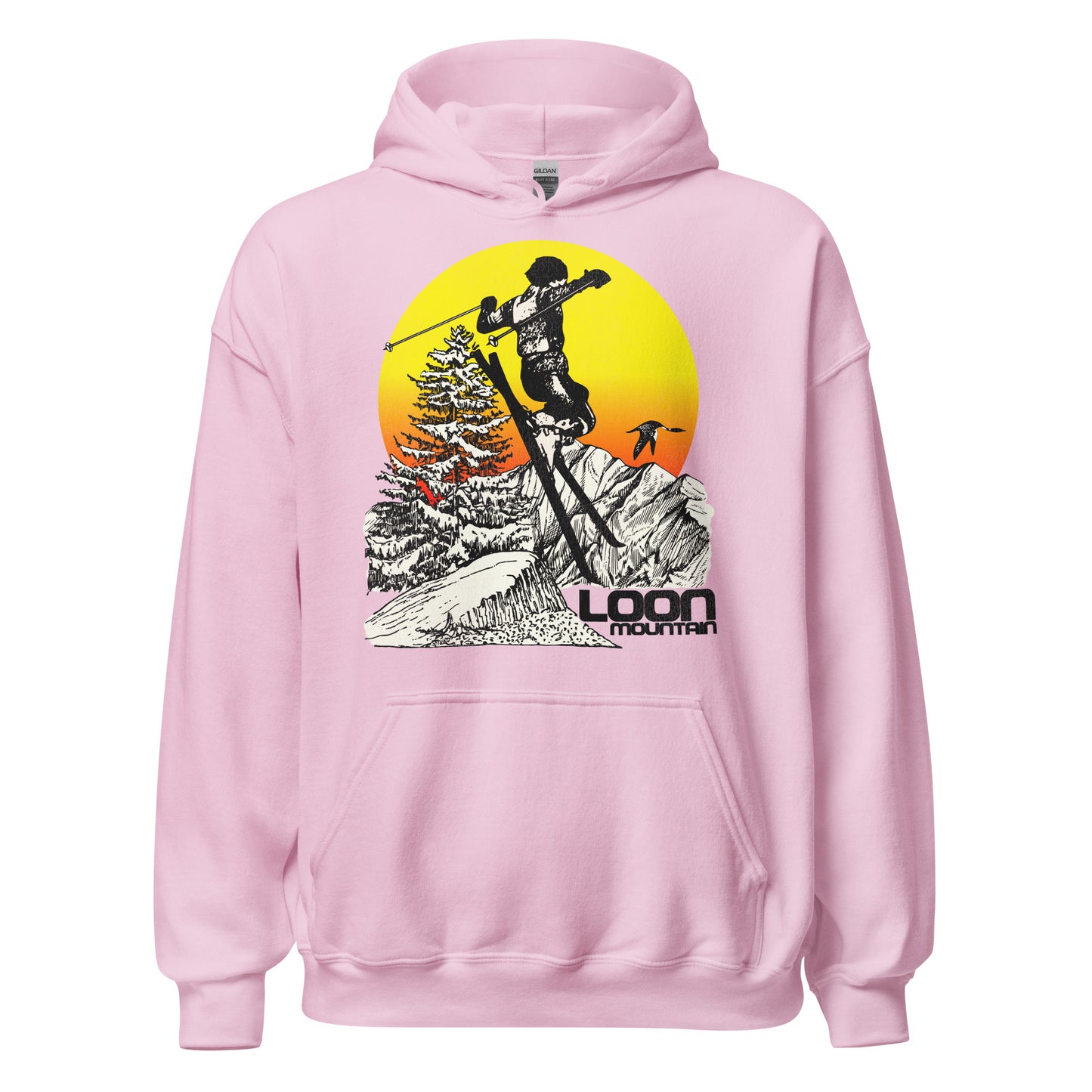 A light pink 80s style retro hooded sweatshirt that says "Loon Mountain" referring to the ski resort in New Hampshire. A woman skiis off a cliff to the backdrop of aspen trees, snow covered mountain range, loon birds, and a bright yellow and red sun. 
