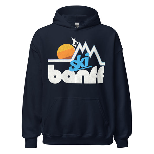 A navy blue Ski Banff travel hooded sweatshirt for tourists. Includes image of a couple triangular mountain peaks, a skier headed down a slope, and a yellow/orange/brown sun rising in the distance. 