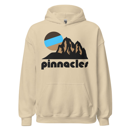 A retro, souvenir Pinnacles National Park sand colored hoodie sweatshirt with the image of multiple rock spire formations under a setting blue and brown stylized circular sun. 