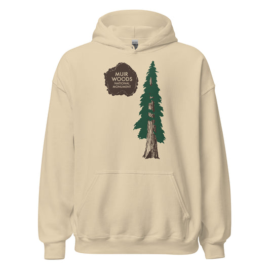 A 70s style sand colored hooded sweatshirt that says "Muir Woods National Monument", managed by the National Park Service and named after conservationist John Muir. Image of a brown paw print from an animal and a tall pine brown and green coastal redwood tree. 