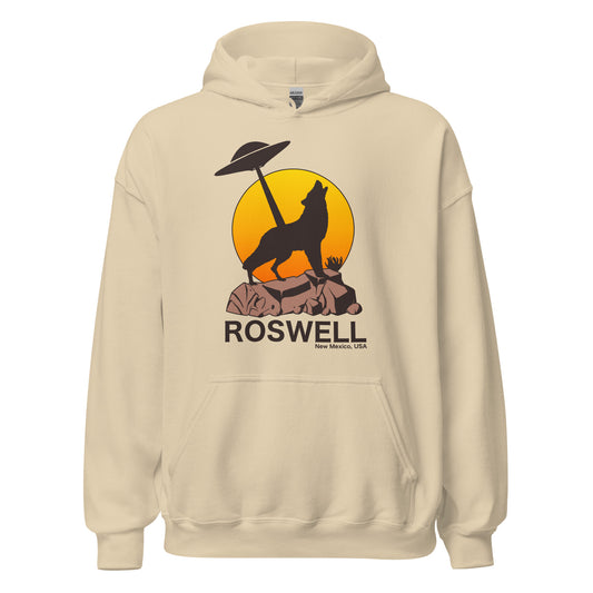 A sand colored tourist Roswell New Mexico, USA hoodie sweatshirt with the image of a wolf on rocky land, an orange and yellow sun, and a UFO. References the Roswell Incident, a 1947 event where debris lead to alien conspiracy theories and catapulted USA into an obsession with UFOs. 