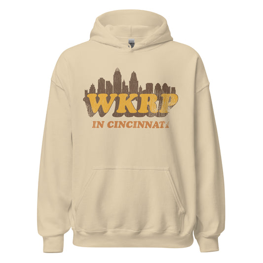 A sand colored retro 70s style WKRP in Cincinnati hoodie sweatshirt in reference to the sitcom TV series which ran in the 70s - 80s with an image of the Cincinnati, Ohio skyline. 