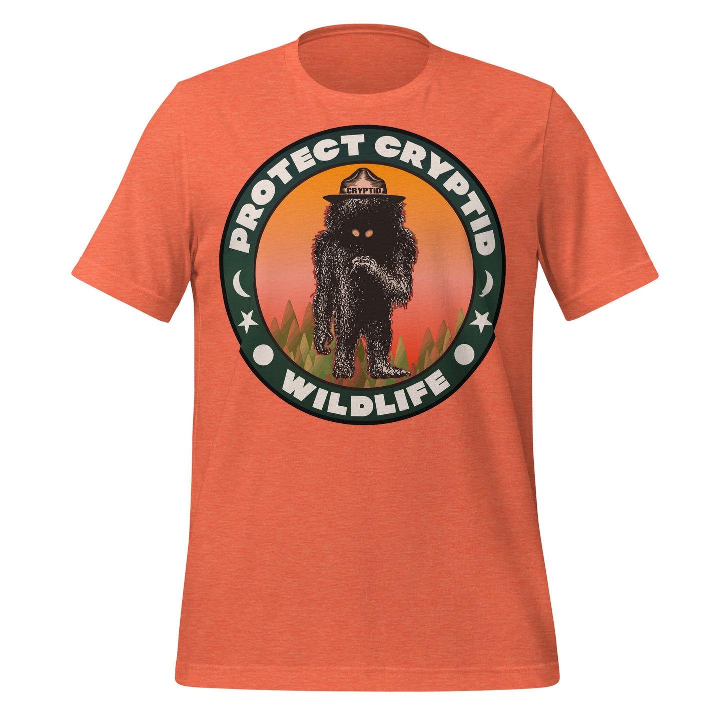 A heather orange retro Protect Cryptid Wildlife t-shirt with the image of an unknown species, a black and hairy creature with yellow eyes, inside a forest against a pink and orange backdrop. 