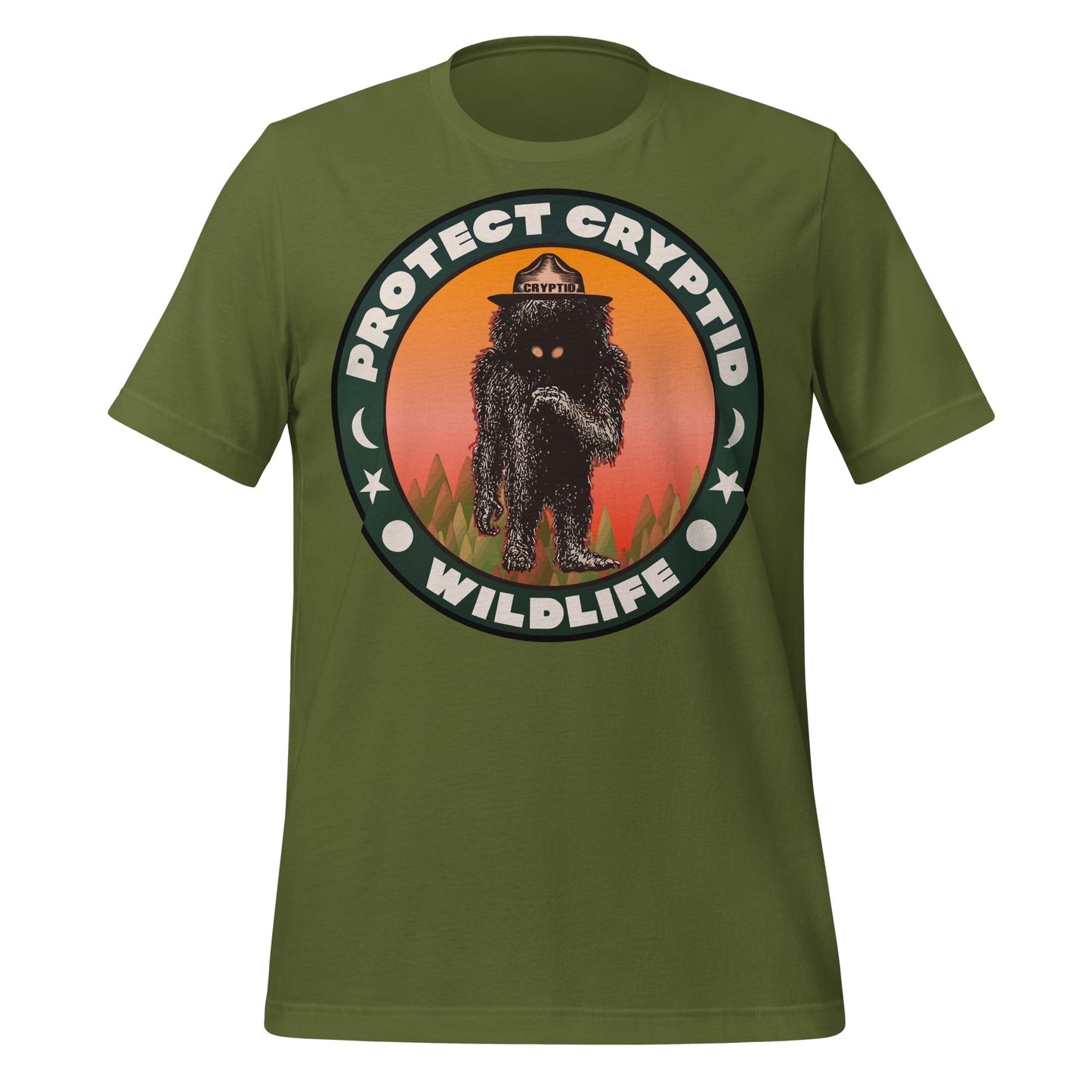 A vintage olive green t-shirt that says Protect Cryptid Wildlife and has image of an undiscovered animal, a black and hairy creature with yellow eyes, inside a green forest against a pink and orange sunscape. Refers to movement to safeguard mythical creatures of the earth.  