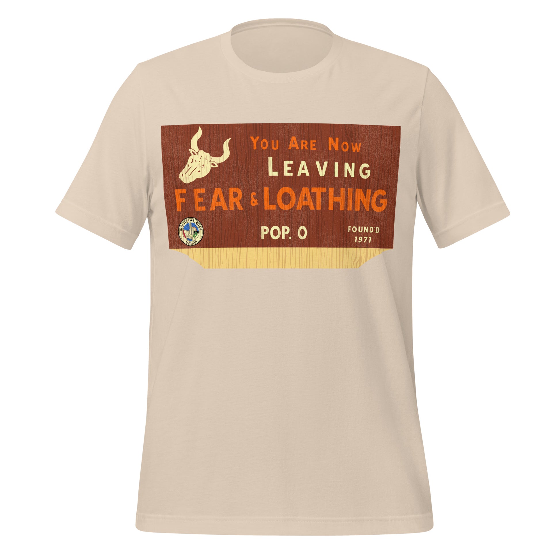 A 70s style soft cream t-shirt for tourists which reads "You are Now Leaving Fear & Loathing", "Pop. 0", and "Founded 1971". Image of the Seal of Las Vegas which says "City of Las Vegas, Nevada" and a horned bull skull on a background which resembles wood. In reference to the film 'Fear and Loathing in Las Vegas' based on the novel by author Hunter S. Thompson. 