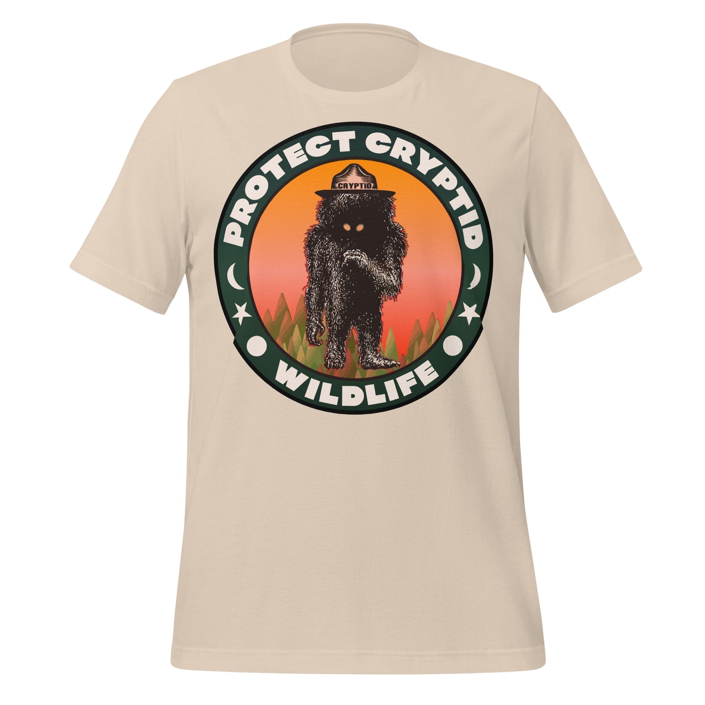 A soft cream vintage short sleeved t-shirt that says "Protect Cryptid Wildlife". Has sun, moon, and star symbols. Image of mythical creature in a forest with a hat that says cryptid and a pink and orange sunrise. 