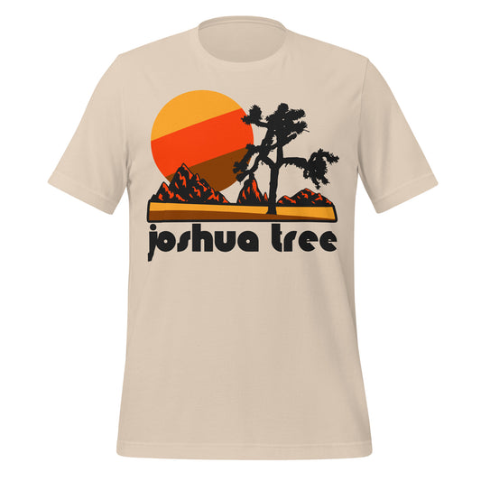 A 80s style vintage soft cream t-shirt with the words Joshua Tree, in reference to the National Park in California. Image of the famous Joshua tree yucca plant, red mountain peaks, and a setting yellow, red, and brown sun. 