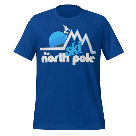 A royal blue retro "Ski the North Pole" short sleeved t-shirt. Image of a skier heading down one of three mountain peaks, a striped blue colored sun setting behind the landscape. 