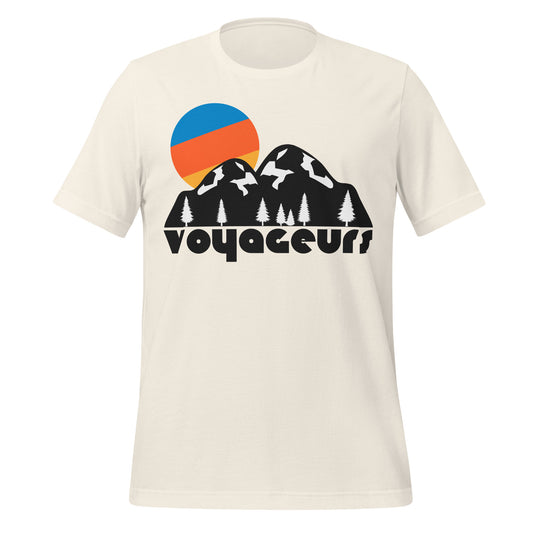 A vintage white colored souvenir tourist t-shirt that says "Voyaguers" under an image of a hilly landscape dotted with evergreen trees against the backdrop of a rising, tricolored sun. References northern Minnesota's Voyageurs National Park, known for its views of the Northern Lights., named after the French-Canadian Voyageurs who explored the waterways. 
