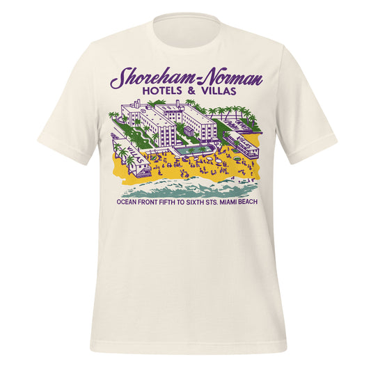 A 60s style off white colored t-shirt with a Florida oceanside hotel, a yellow sand, palm trees, beach partiers, and two villas that says "Shoreham-Norman Hotels & Villas Ocean Front Fifth to Sixth Sts. Miami Beach."