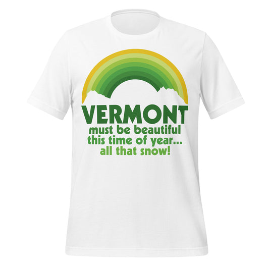 A short sleeved white colored 80s style retro t-shirt that says "Vermont must be beautiful this time of year... all that snow!" Image of a green and yellow rainbow with the outline of mountains in front. References the famous quote from the 1954 classic movie White Christmas from the conversation between Judy Haynes and Phil Davis. 